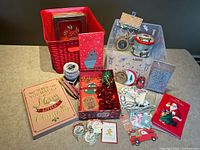Full lot showing storage bins, tins, gift box, greeting cards, tags, bows, twine and embellishments