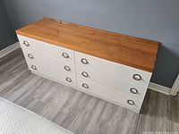 front view showing six drawers, teak top, metal pulls
