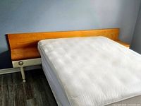 Headboard installed behind mattress showing right nightstand