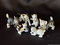 Group shot of all six porcelain cat figurines showing poses and paint details