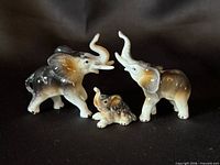Front view of three porcelain elephant figurines