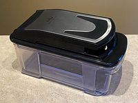 Chopper closed on container, showing stainless top and clear box