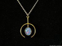 Front view of pendant showing gold-tone open frame and opal mosaic cabochon on chain