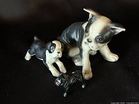 Front view of three dog figurines on black background