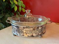 Casserole with lid seated in silverplate stand, overall view