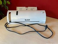 Front view of Scotch TL902-C laminator showing feed slot, brand logo, attached cord