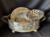 All four silver-plated pieces grouped: oval holder, pedestal compote, small pierced dish, round trivet