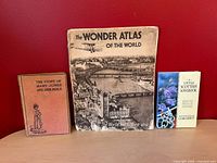 Front covers of all three books displayed upright on surface