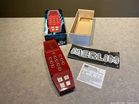 Handheld game with box, tray, overlay and manual laid out