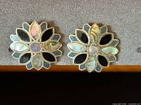 Front view of both earrings showing sunburst design and inlay materials