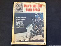 Front cover showing title, lunar module image, edge wear and tear