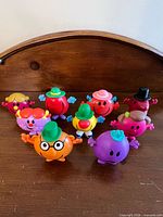 Group shot of all nine Mr. Men and Little Miss figures on wooden surface
