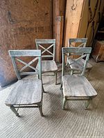 Four wooden cross-back chairs front view