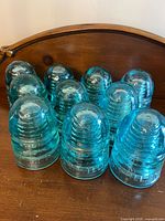 Group of ten aqua glass insulators showing overall quantity and color