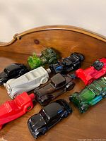 Top view of all ten colored glass car bottles on wooden surface