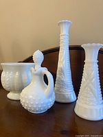 Front view of all four milk glass pieces