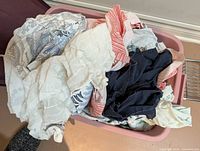 Top view of pink plastic bin containing mixed fabric remnants in various colors and patterns
