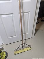 Full view of broom showing wooden handle and head