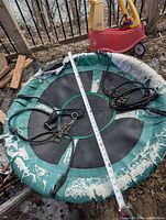 Top view of round swing showing fabric seat, wear, ropes, hardware, and tape measure across diameter