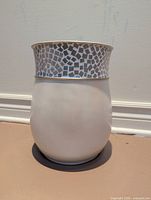 Front view of white wastebasket showing mosaic tile rim