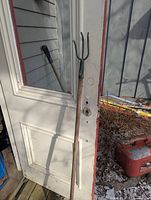 Full view of cultivator showing three-tine head and wood handle