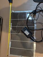 Top view of FermWrap heat mat with measuring tape showing 23-inch length, wired thermostat controller and probe visible