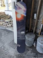 Full view of Firefly snowboard leaning against wall