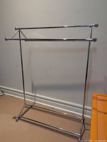 Full view of chrome metal freestanding towel rack showing two towel bars and base