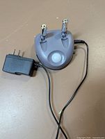 Grey dual-laser parking guide with motion sensor and attached power adapter