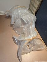 Folded transparent plastic tunnel cloche with hoops visible