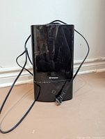 Front view of black Westinghouse humidifier with attached power cord and plug