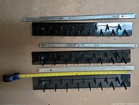 Three Ikea sliding hook racks with tape measure showing 22 in length