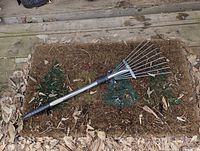 Full view of telescopic hand rake on doormat