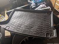Top view of molded black Hyundai Kona trunk liner showing grid texture and raised edges