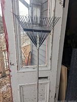 Full view of rake showing metal head and wood handle