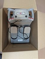 Flight yoke and rudder pedals set placed in cardboard box, cables visible, Pro Pedals label readable