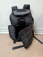 Front view of black photography backpack showing side access flap open