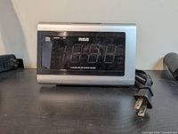 Front view showing RCA branding, LED display, attached power cord