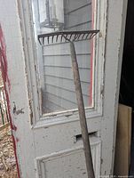 Full view of rock rake leaning against door