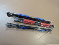 Three black socket rails with red and blue clips sealed in plastic