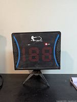 Front view of speed radar showing LED display, logo, indicators, and tripod