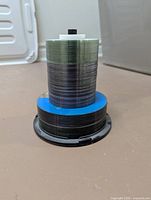Two spindles of blank optical discs, smaller diameter stack on top of larger
