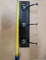 Front view showing entire coat rack and measurement tape indicating ~18 in width