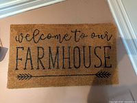 Top view of the rectangular brown coir doormat showing full text and design