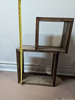 Front view of wood geometric shelf with measuring tape showing height