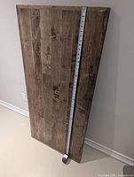 Full view of wood panel front, measuring tape indicating length ~54 in