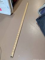 Full view of the wooden yardstick showing measurement markings