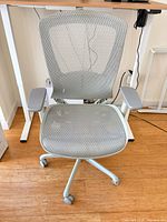 Front view of grey mesh adjustable rolling desk chair