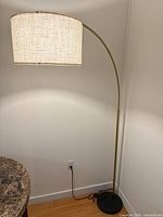 Full view of arc floor lamp, shade illuminated