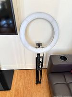 Ring light folded on stand beside sofa